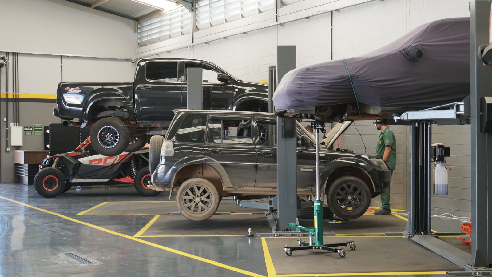 Boxes de serviço da Dakar com veículos nos elevadores