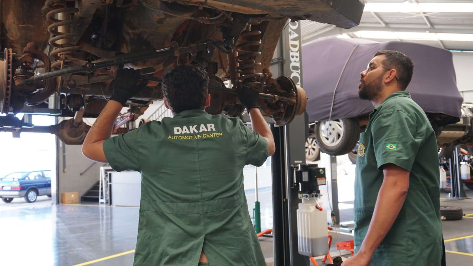 Equipe da Dakar avaliando um veículo no elevador